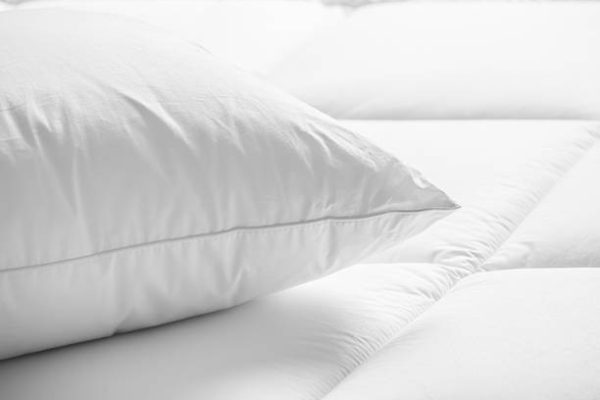 Closeup of white pillow on the bed in the bedroom